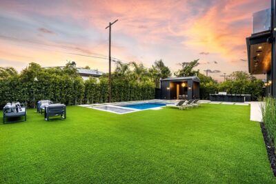 Modern backyard with pool and lounge chairs at sunset